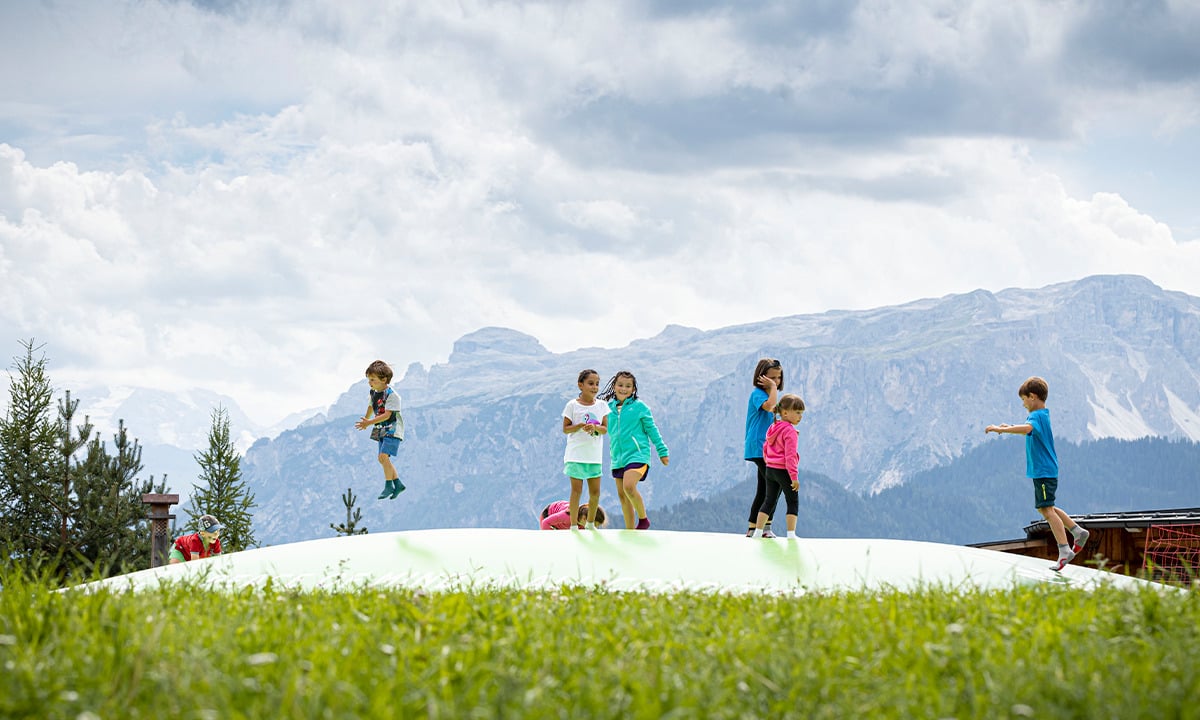 Afbeelding van een airmountain springkussen midden op een berg met spelende kinderen